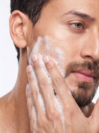 Tiger Shroff massaging a foaming face wash lather onto his cheek.