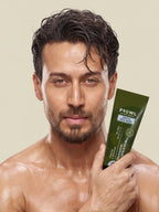 Tiger Shroff with wet hair and skin posing with a tube of PROWL Gentle Face Wash.