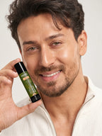 Smiling Tiger Shroff holding a tube of PROWL Daily Lip Balm close to his face against a white background.